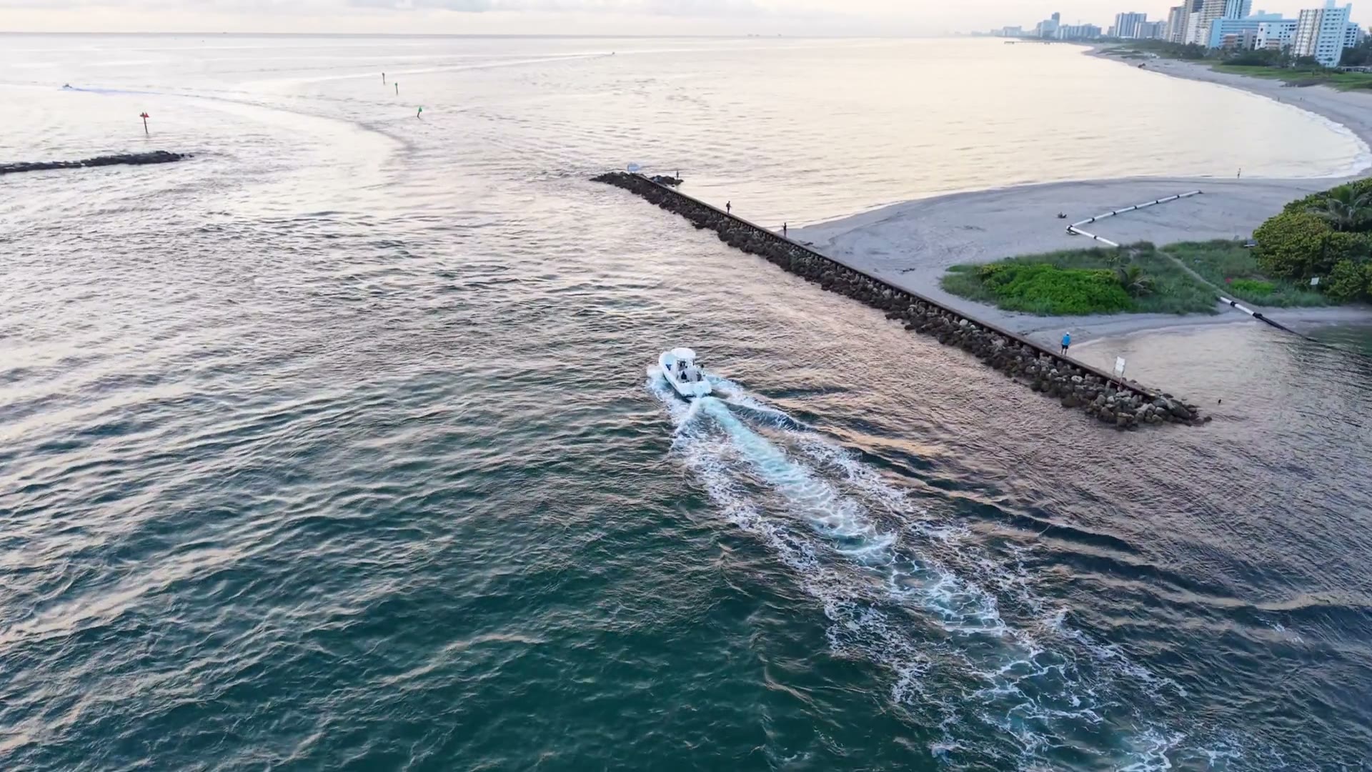 Boat crossing a South Florida inlet at dawn, aerial video still